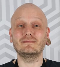 A portrait picture of Jaakko Iisala against the Eficode hexagon background canvas.